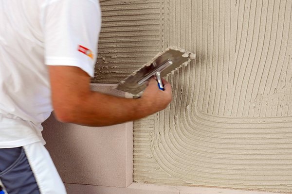 Kleber auf Wand auftragen